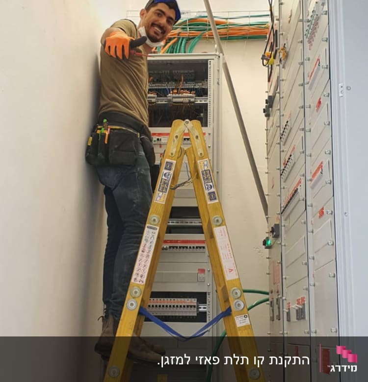 חשמלאי על סולם ליד לוח חשמל פתוח
